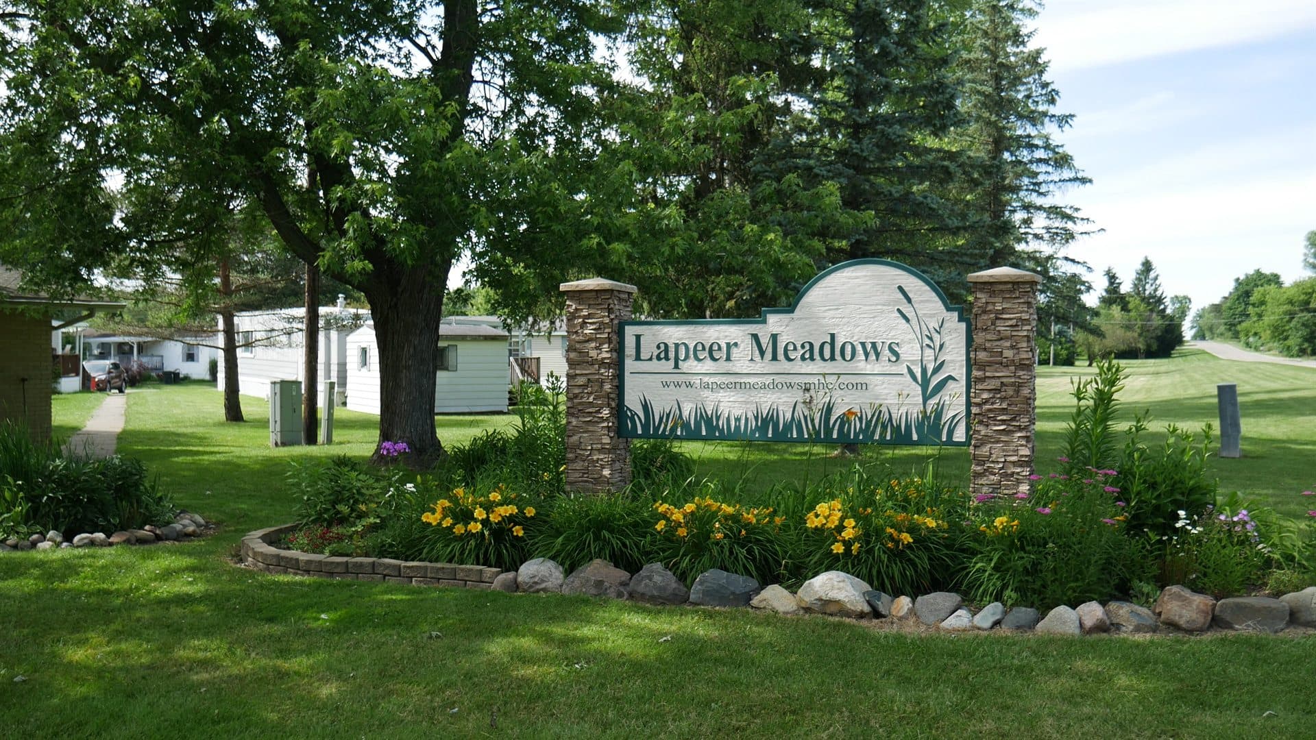 Lapeer Meadows entrance sign with landscaped flower beds